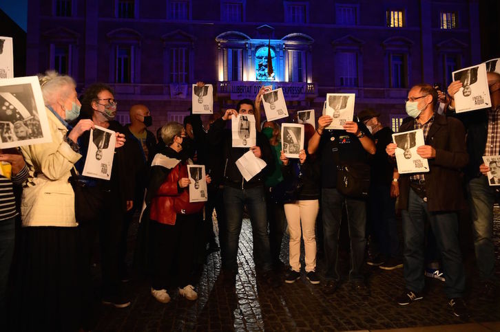 Un grupo de personas con fotografías de Felipe VI boca abajo. (Lluís GENE/AFP)