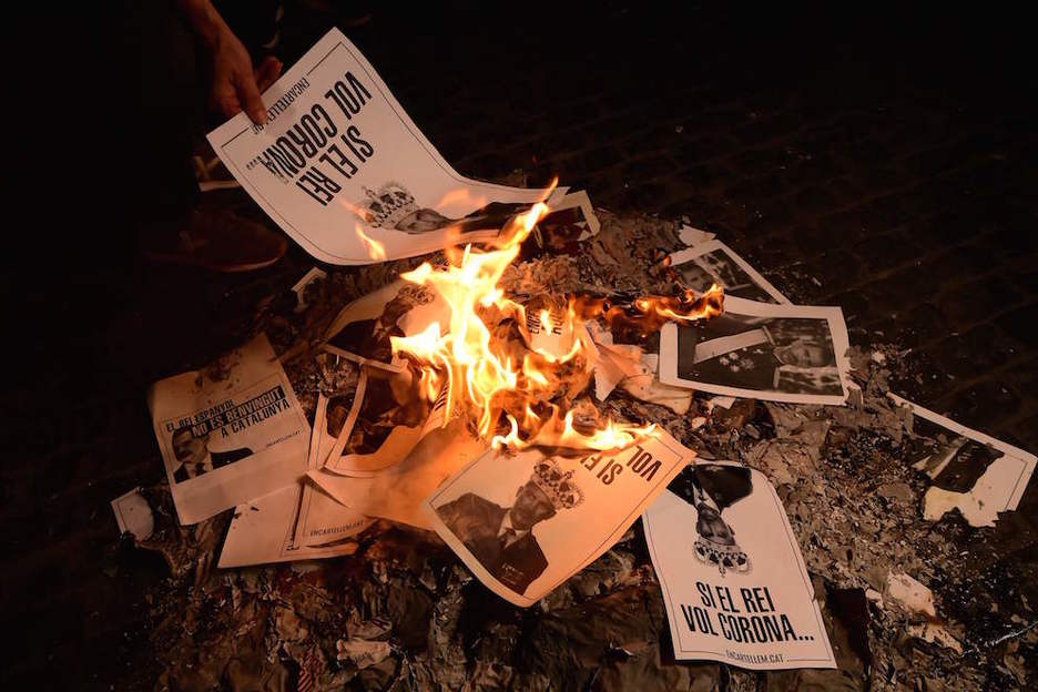 Una mini-hoguera con las fotos quemadas de Felipe de Borbón. (Lluís GENE/AFP)