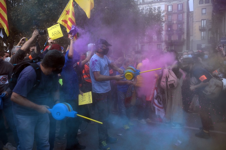 Ante el despliegue policial, los concentrados han tirado polvos de colores a los Mossos. (Josep LAGO | AFP)