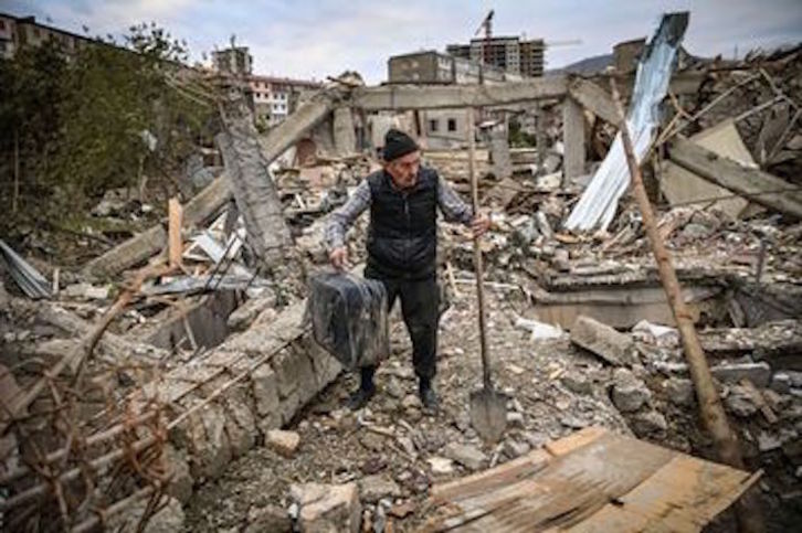Un hombre busca entre los escombros de su casa en Stepanakert, reducida a ruinas en un bombardeo. (Aris MASSINIS/AFP)