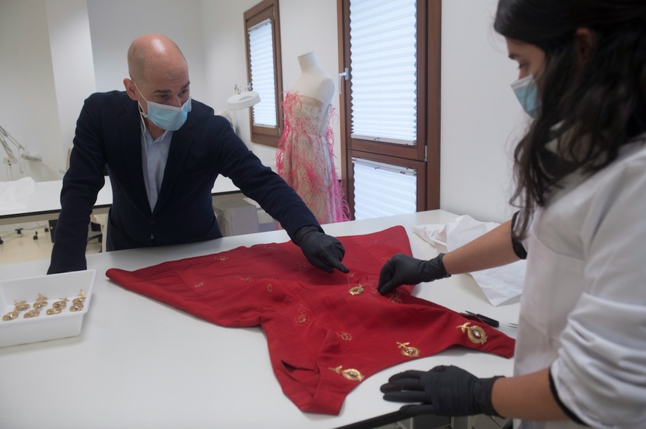 Igor Uria y Ruth Valentín restauran el vestido sobre la mesa de trabajo. (Juan Carlos RUIZ I FOKU)