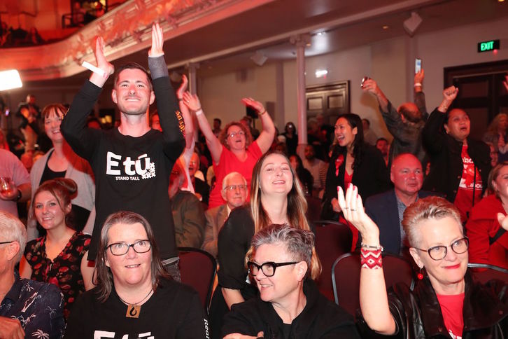 Miembros del partido Laborista celebran en Auckland la victoria Ardern. (Michael BRADLEY/AFP)