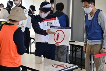 Un operario hace indicaciones a un voluntario (Charly TRIBALLEAU / AFP)