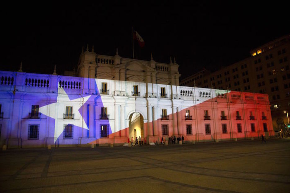 El palacio de La Moneda, sede del Ejecutivo y donde Salvador Allende falleció durante el golpe militar encabezado por Pinochet, engalanado con la bandera chilena. (Claudio REYES/AFP)