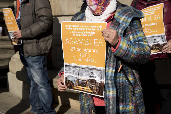 Un integrante de Zainduz muestra el cartel de la asamblea que han tenido que suspender, en la presentación de la asociación el pasado lunes en Iruñea. (Iñigo URIZ/FOKU)