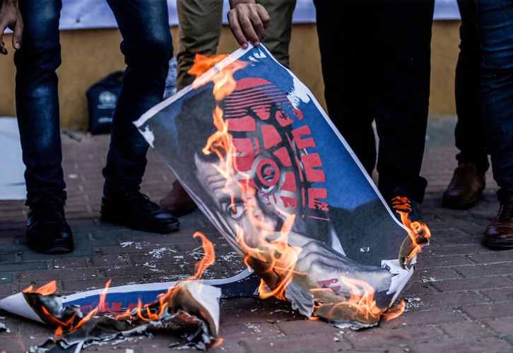Manifestantes queman en Gaza un cartel con la cara de Macron pisoteada. (Mahmud HAMS/AFP)