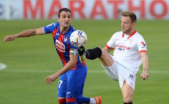 Rakitic intenta despejar un balón ante Kike en el partido del domingo en el Sánchez Pizjuán. (Cristina QUICLER/AFP)