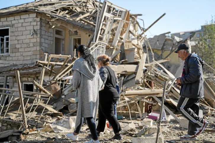 Dos mujeres caminan sobre los escombros de su casa en Stepanakert. (Pablo GONZÁLEZ)