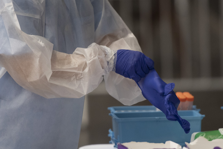 Una sanitaria se ajusta los guantes para hacer pruebas PCR. (Gorka RUBIO | FOKU)