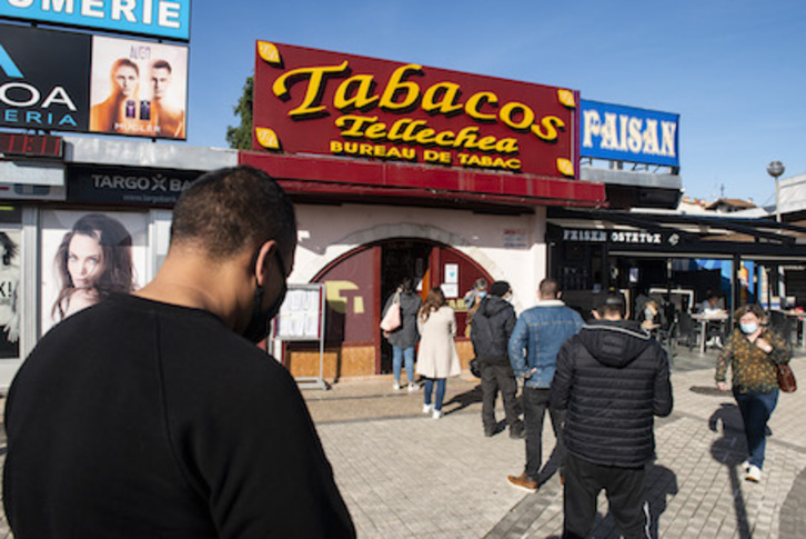 Bezeroak tabakoa erosteko ilara egiten Behobiako saltoki batean. (Guillaume FAUVEAU)