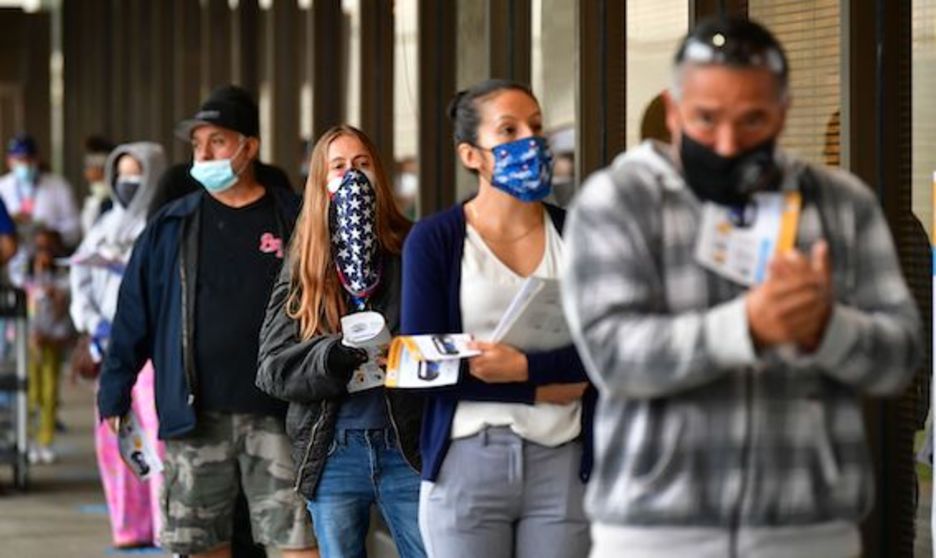 Votantes con mascarilla mientras esperan en línea para votar en el Registrador del Condado de Los Ángeles en Norwalk, California. (Frederic J. BROWN/AFP)