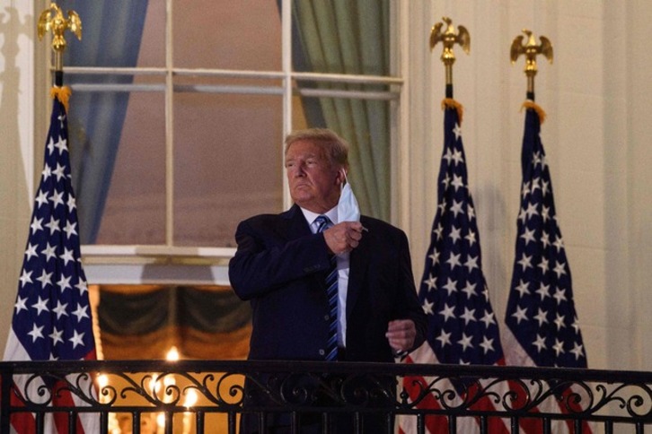 Trump retirándose la mascarilla, en una imagen de archivo. (Nicholas KAMM/AFP)