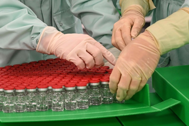 Técnicos de laboratorio con test de la vacuna contra la covid-19. (Vincenzo PINTO/AFP)