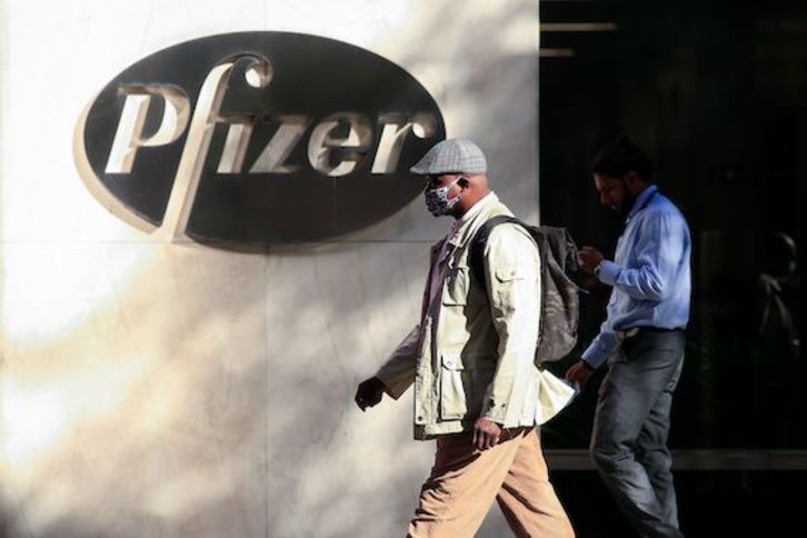 Un hombre camina por la sede central de Pfizer en Nueva York. (Kena BETANCUR/AFP)