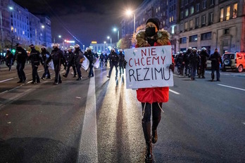 Una manifestante sujeta un cartel ante el despliegue policial el pasado 9 de noviembre. (Wojtek RADWANSKI/AFP)
