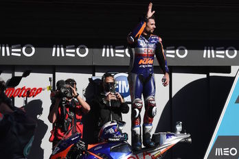 Miguel Oliveira saluda subido a de su moto tras lograr la victoria en «su» casa. (Patricia DE MELO MOREIRA/AFP)