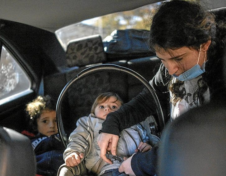 Tina Kenejian acomoda a sus dos hijos en el coche durante una de sus muchas partidas. (Gilad SADE)