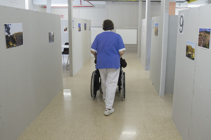 Una sanitaria traslada a un residente en la Casa de la Misericordia de Iruñea. (Iñigo URIZ/FOKU)