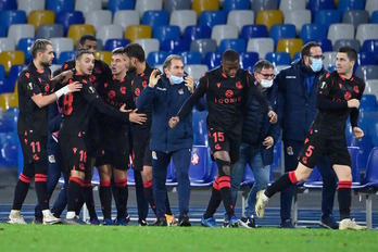 Los jugadores de la real celebran el empate y el pase con parte del staff técnico. (Alberto PIZZOLI/AFP)