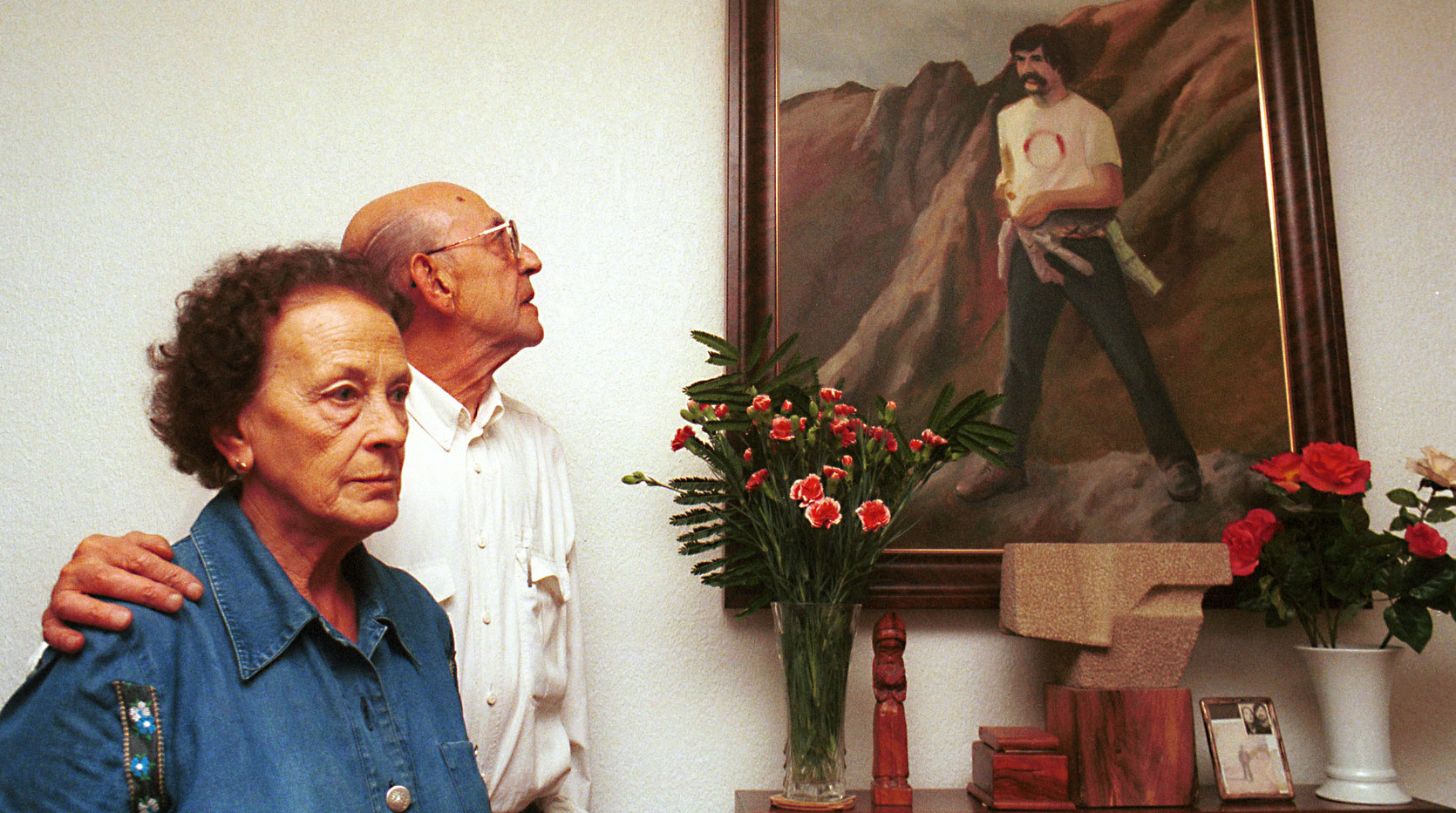 Patxiku Etxeberria y Celes Álvarez miran el retrato de su hijo José Miguel, en 1999. (Jagoba MANTEROLA | FOKU)