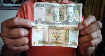 Billete de un peso cubano (arriba) y de un peso convertible (abajo) que pronto desaparecerá (Foto: Adalberto ROQUE | AFP)