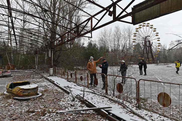 Turistas, junto a un parque de atracciones abandonado de la ciudad de Prípiat. (Genya SAVILOV/AFP)