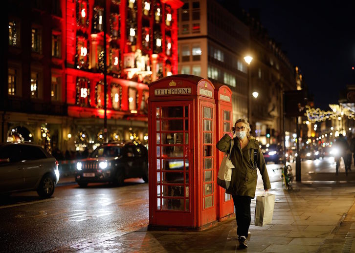 Una mujer pasea sola en Londres antes de que se declare el Tier 4 en toda la ciudad. (Tolga AKMEN/AFP) 