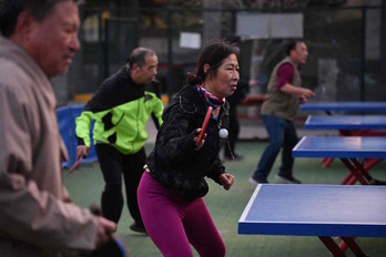 Una mujer china juega a ping-pong entre hombres en la capital. (Greg BAKER | AFP)
