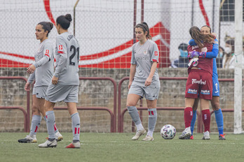 Las rojiblancas se retiran abatidas del campo mientras las jugadoras del EDF celebran la victoria. (LaLiga)