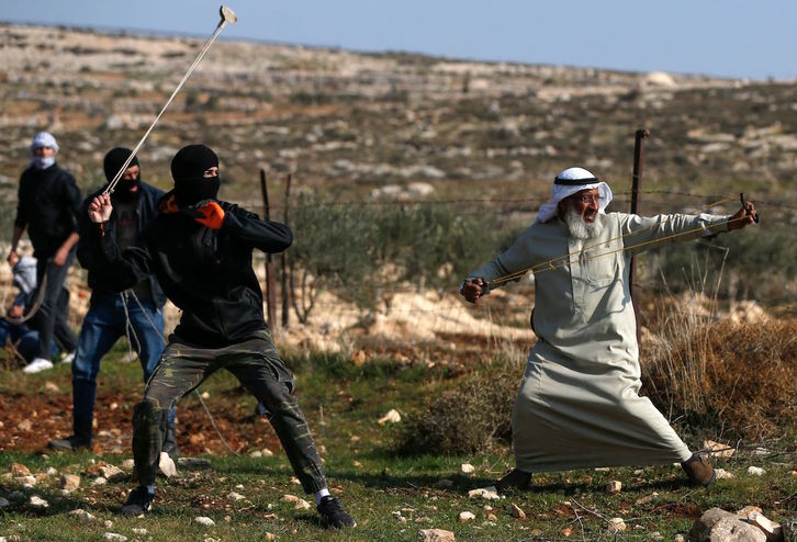 Palestinos con hondas y tiragomas lanzan piedras al Ejército israelí. (ABBAS MOMANI / AFP) 