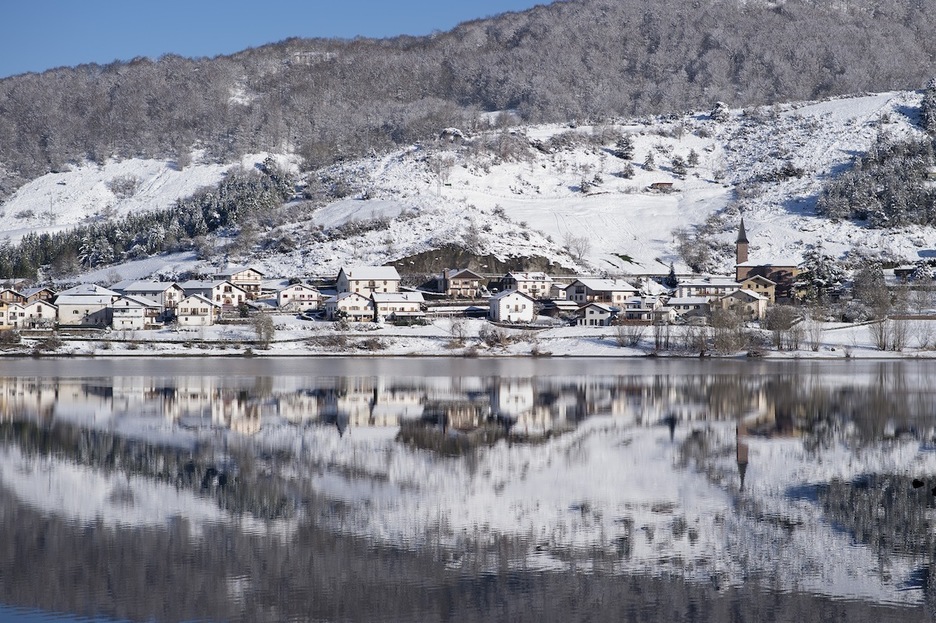 Estampa invernal del pueblo de Eugi, reflejado en las tranquilas aguas del pantano. (Iñigo URIZ/FOKU)