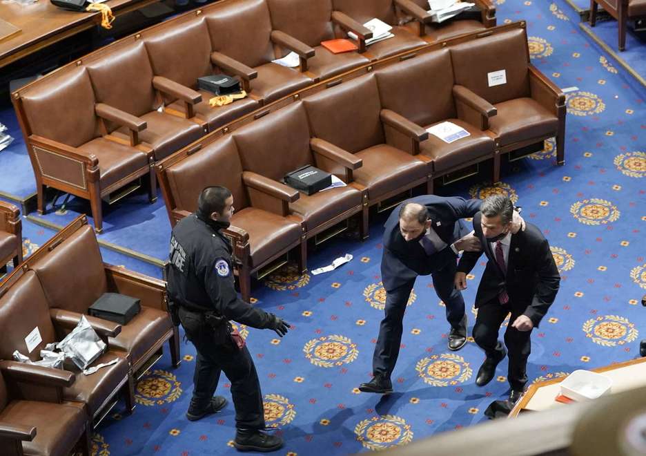 Miembros del Congreso salen del edificio para protegerse. (Drew ANGERER/AFP)