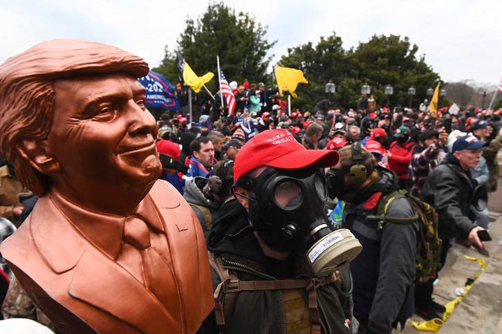 Seguidores de Trum con máscaras de gas y un busto del magnate ante el Capitolio. (Roberto SCHMIDT/AFP)