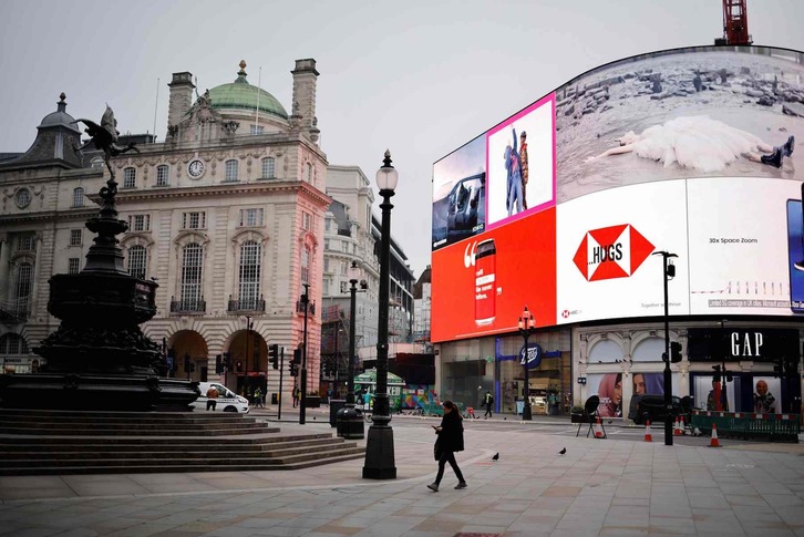 Una mujer cruza un Leicester Square casi desierto en el centro de Londres. (Tolga AKMEN/AFP)