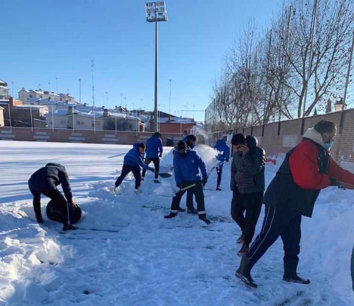 Jugadores y aficionados del Navalcarnero han comenzado a limpiar el campo esta mañana. (CDA Navalcarnero)