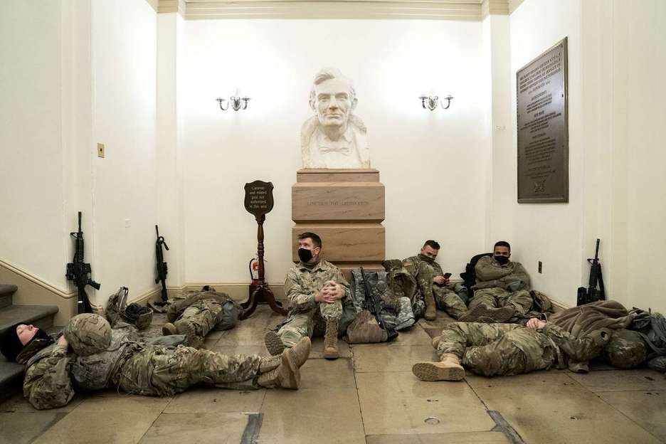 Miembros de la Guardia Nacional descansan en la Rotonda del Capitolio de EEUU en Washington. (Saul LOEB/AFP)