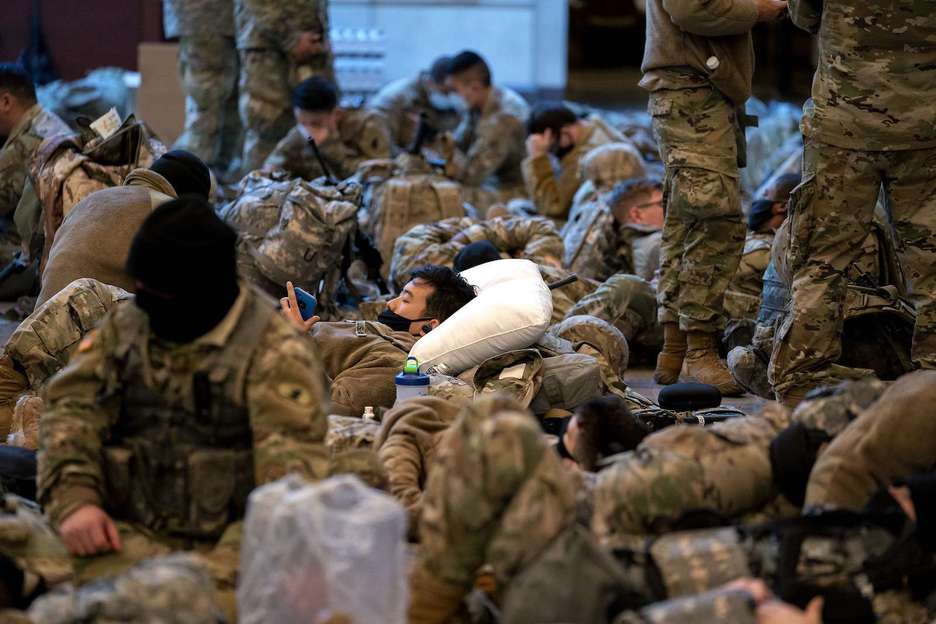 Miembros de la Guardia Nacional duermen en el Centro de Visitantes del Capitolio. (Stefani REYNOLDS/AFP)