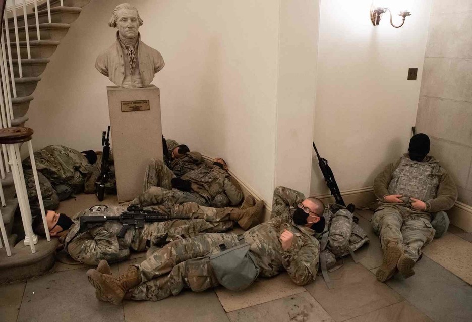 Soldados descansan bajo la estatua de Geoge Whasington. (Saul LOEB/AFP)