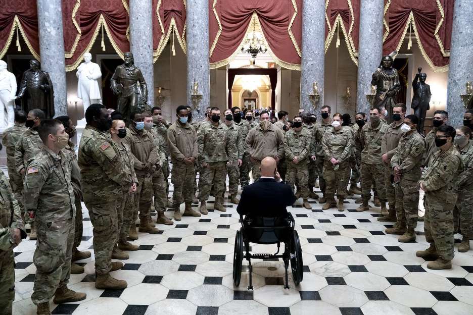El representante Brian Mast ofrece a los miembros de la Guardia Nacional una visita por el Capitolio. (Stefani REYNOLDS/AFP)