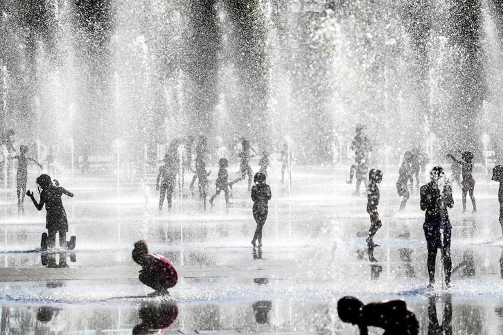 Niños jugando bajo el agua durante la ola de calor de junio de 2020 en Niza. (Valery HACHE/AFP)