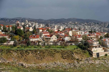 Una imagen tomada el 20 de enero muestra el asentamiento israelí de Pisgat Zeev en el este de Jerusalén (primer plano) y la aldea de Hizma en Cisjordania (al fondo). (Ahmad GHARABLI/AFP)
