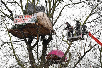 Policías tratan de bajar a los activistas instalados en tiendas de campaña en los árboles del parque Euston.Justin TALLIS/AFP)