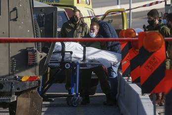 Soldados israelíes trasladan el cuerpo del palestino muerto. (HAZEM BADER / AFP) 