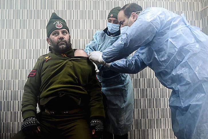 Vacunando a un policía en India. (Tauseef MUSTAFA | AFP)