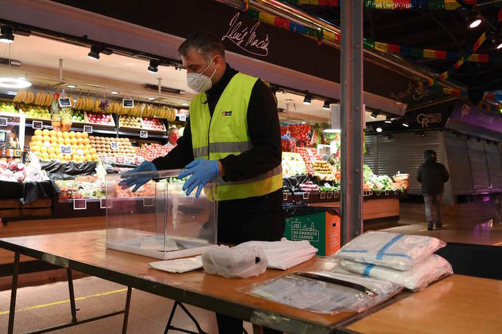 Hauteskunde mahaietako kideen faltan, mahaiak osatzeko materiala hauteslekuetan dago jada. Kasu askotan, ez dira ohiko hauteslekuak izanen, ordea. Irudian, Bartzelonako merkatu batean jarritako mahaiak. (Lluís GENÉ/AFP)