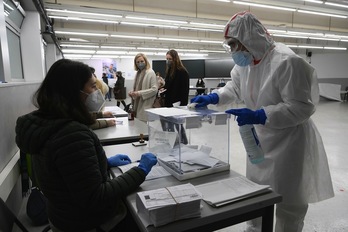 Personal sanitario desinfecta una urna en un colegio electoral de Barcelona. (Lluís GENÉ/AFP)