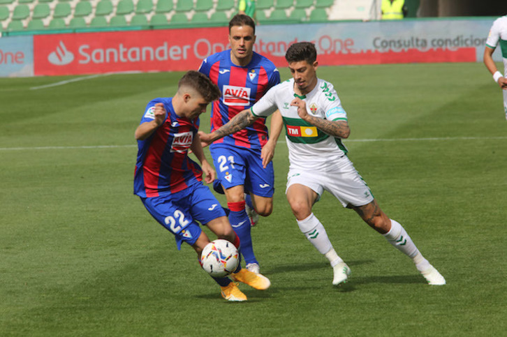 Pozo se hace con el balón ante Rigoni en presencia de Pedro León. (Chimo De Haro/LOF)