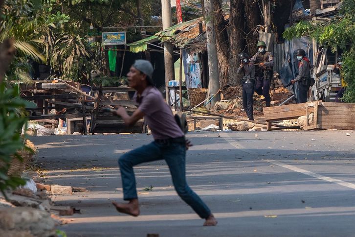 Polizia arma batekin apuntatzen Myanmarreko kolpe militarraren aurkako manifestazio batean. (STR/AFP) 
