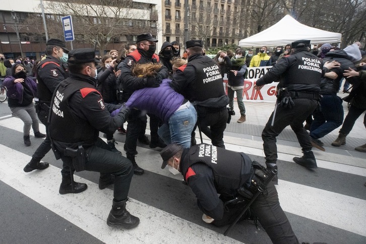 Varios policías forales se emplean con fuerza con una de las manifestantes. (Iñigo URIZ/FOKU)