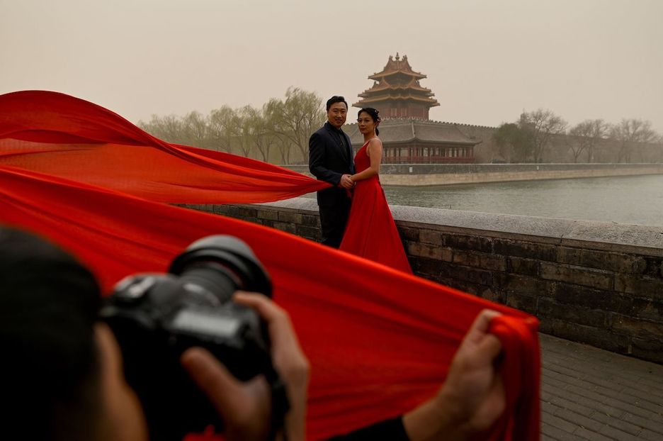 Una pareja recién casada posa para su reportaje fotográfico de boda ante la Ciudad Prohibida. (Wang ZHAO/AFP)